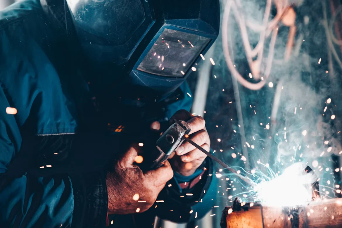 Welder in a protective helmet working with sparks flying